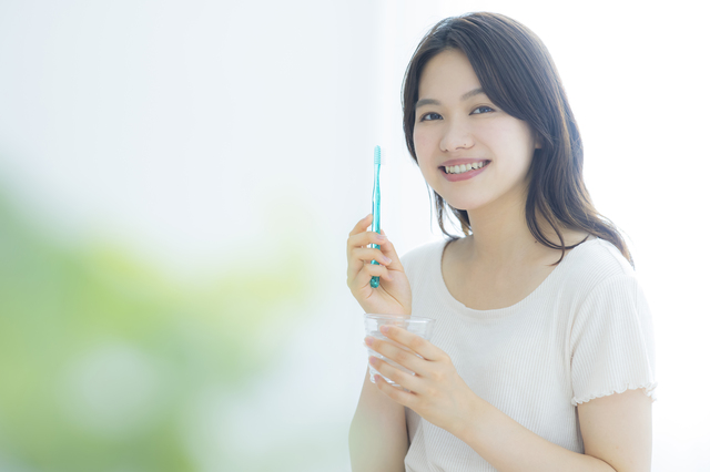 歯ブラシを握る女性